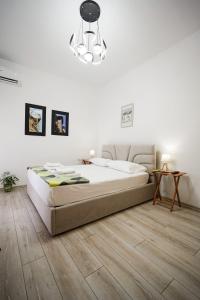une chambre avec un grand lit et un lustre dans l'établissement View City Apartments, à Gjirokastër