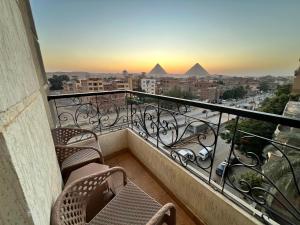 a balcony with chairs and a view of the pyramids at King Khafren Pyramids View in Cairo