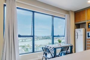 a kitchen with a table and chairs and a large window at TVT - Luxury studios in the center of Florianópolis in Florianópolis