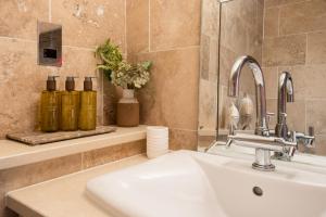 ein Badezimmer mit Waschbecken und Spiegel in der Unterkunft Pol!cehouse Cottages, Embleton in Alnwick