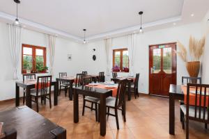a dining room with tables and chairs and windows at Green lakes house in Plitvička Jezera