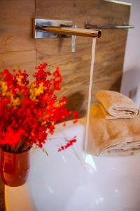 a vase of flowers sitting on a bathroom sink at Hotel Gredos María Justina in Navacepeda de Tormes