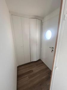 an empty room with white walls and wood floors at L'appart D79 in Gruissan +15 photos