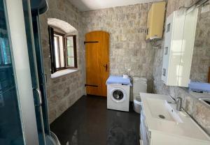 a small bathroom with a washing machine and a washer at Stone Apartment Risan in Risan