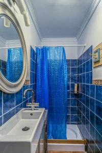 a blue tiled bathroom with a tub and a sink at La casa de la Fuente Vieja in Villanueva de los Infantes