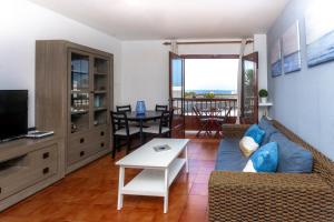 Una sala de estar con un sofá y un televisor. en Casa Playa María, en Agaete