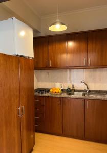 eine Küche mit Holzschränken und einer Spüle in der Unterkunft Quinta da Graça Casa do Artista in Resende + 10 Fotos