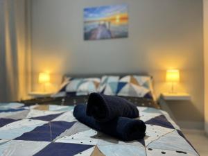 Una cama con sombrero y toallas. en LEX Apartments, en Bucarest