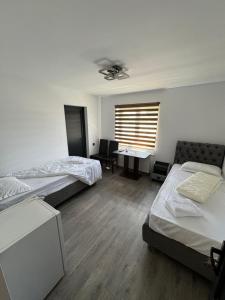 a room with two beds and a desk with a window at Viv House in Vălenii de Munte +11 photos