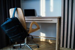 een rugzak die op een stoel naast een bureau ligt bij Apartamenty I SORAU in Żary