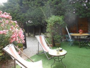 a patio with two chairs and a table and flowers at Maison la ciotat in La Ciotat +2 photos