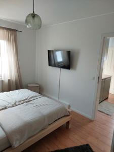 a bedroom with a bed and a television on the wall at Ferienwohnung Schwingestraße in Dinghorn
