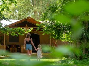 雷讷瑟Ecolodges De Dreef的妇女和儿童在房子前行走