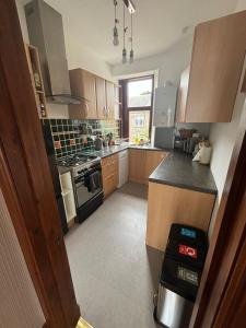 a kitchen with wooden cabinets and a stove top oven at My Alba Home in Fife