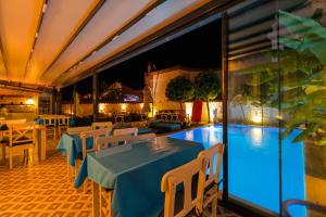a restaurant with a swimming pool and tables and chairs at Kybele Suites Alaçatı in Alaçatı