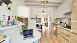 a kitchen with a table with a laptop on it at Merlo Holiday Room in Palermo +16 photos
