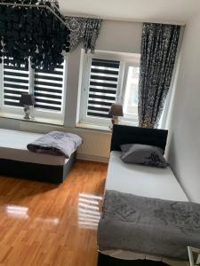 a bedroom with two beds and two windows at Unterkunft Ferienwohnung Mara Oberhausen in Oberhausen