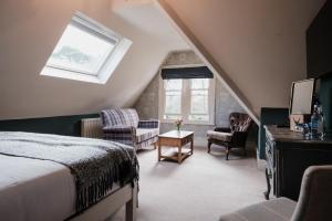 una camera mansardata con letto e finestra di The White Buck a Burley