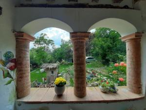 a window with a view of a garden with flowers at Oobeh Country House in Roncovetro
