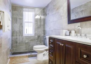 a bathroom with a shower and a toilet and a sink at Ocean Drive apartment w Balcony Walk to the Beach in Miami Beach +25 photos