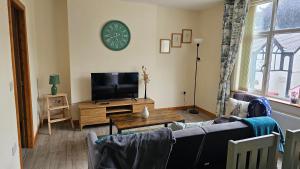 a living room with a couch and a tv at The Apartment at Brook House in Llanberis