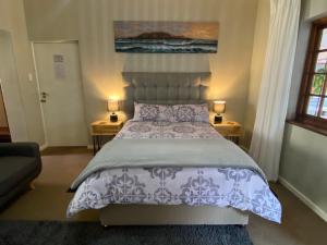 1 dormitorio con 1 cama y 2 mesas con lámparas en Garden Home in Upper Walmer, en Gqeberha