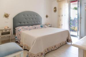 a bedroom with a large bed and a window at RoRo Home Via Del Mare in Orosei