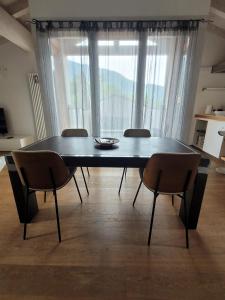 a dining room table with chairs and a large window at Casa Kamil in Brusino +17 photos