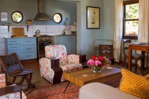 a living room with a table and chairs and a kitchen at Trengwainton Cottage in Hogsback