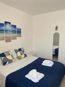a bedroom with a blue bed with towels on it at HYPOGEUM -Le Torri Apartments- in Otranto