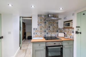 a kitchen with a stove and a counter top at Grade 2 Cottage 1 bedroom, Ludlow centre in Ludlow