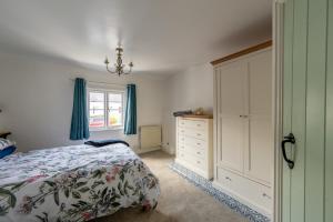 a bedroom with a bed and a dresser and a window at Grade 2 Cottage 1 bedroom, Ludlow centre in Ludlow