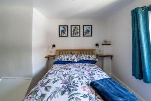 a small bedroom with a bed with blue curtains at Grade 2 Cottage 1 bedroom, Ludlow centre in Ludlow