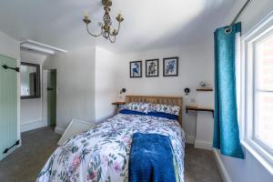 a bedroom with a bed with blue curtains at Grade 2 Cottage 1 bedroom, Ludlow centre in Ludlow