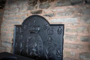 a metal object with a crown on a brick wall at Grade 2 Cottage 1 bedroom, Ludlow centre in Ludlow