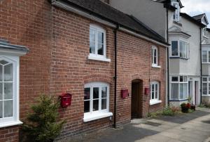 a brick house with a christmas tree in front of it at Grade 2 Cottage 1 bedroom, Ludlow centre in Ludlow