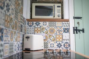 a kitchen with a microwave on a tiled wall at Grade 2 Cottage 1 bedroom, Ludlow centre in Ludlow