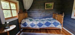 a bedroom with a bed in a log cabin at Rentukka - Sähköttömät Yöpymismökit - Off-grid Cottages in Såris +16 photos