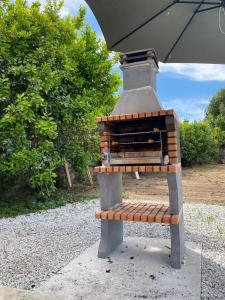 a grill sitting on a bench under an umbrella at Casa Augusta - QUINTA in Penafiel