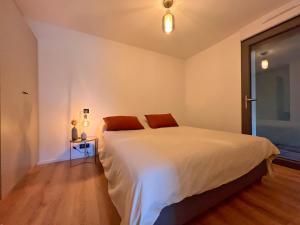 a bedroom with a large white bed and a table at Premium surf lodge in Capbreton