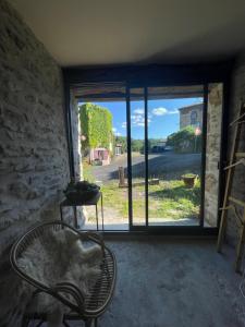 a room with a chair and a large window at Chez la ptite famille in Saint-Didier-sur-Doulon