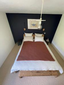 a bedroom with a large bed with a blue wall at Chez la ptite famille in Saint-Didier-sur-Doulon +2 photos