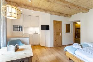 a kitchen and living room with a bed and a table at Chesa-Strimer - Studio in La Punt-Chamues-ch