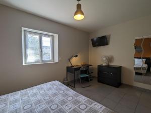 a bedroom with a bed and a desk and a window at Chambre PMR avec Salle d'Eau Privative, Grande Lit, et Petit-Déjeuner Inclus in Neuvy-Saint-Sépulchre - FR-1-591-608 in Neuvy-Saint-Sépulchre