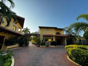 a house with a brick driveway and palm trees at Porto Bello Hotel Boutique in Puerto Colombia