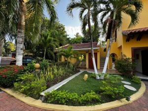 a house with palm trees in front of a yard at Porto Bello Hotel Boutique in Puerto Colombia +116 photos