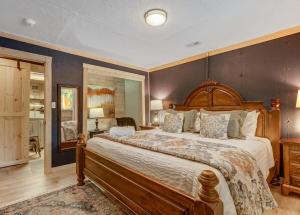 a bedroom with a large bed with a wooden headboard at Pinetop Cabin Hot Tub BBQ Arcade Scenic Escape in Florissant