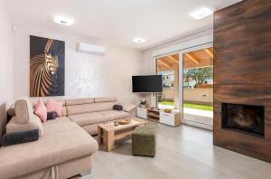 salon z kanapą i kominkiem w obiekcie Villa Jessica w mieście Bibići