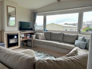 a living room with a couch and a television at 23 Kestrel quays in Flamborough