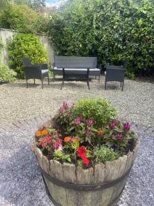 two benches and a planter with flowers in a garden at Grade 2 Cottage 1 bedroom, Ludlow centre in Ludlow